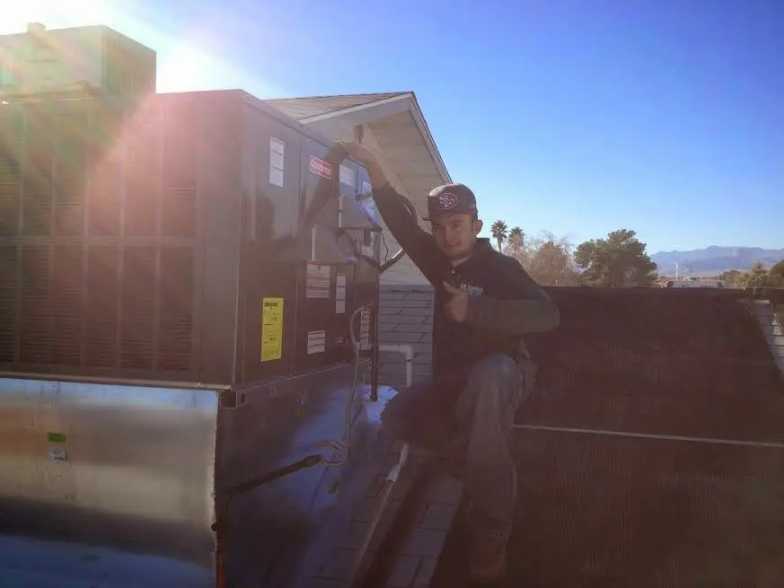 HVAC technician performing AC Tune-Up on a rooftop unit in Vicksburg