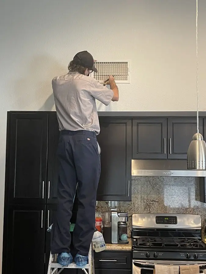 Technician inspecting an air vent during HVAC service in Vicksburg